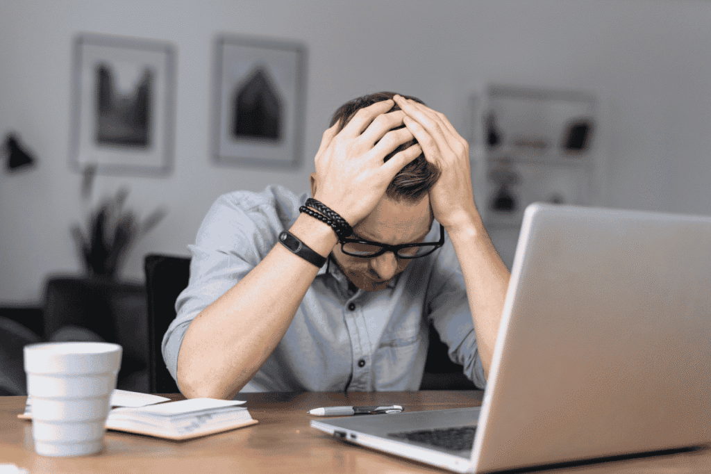 Stressed person reviewing finances on a laptop